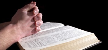 Clasped Hands over Bible